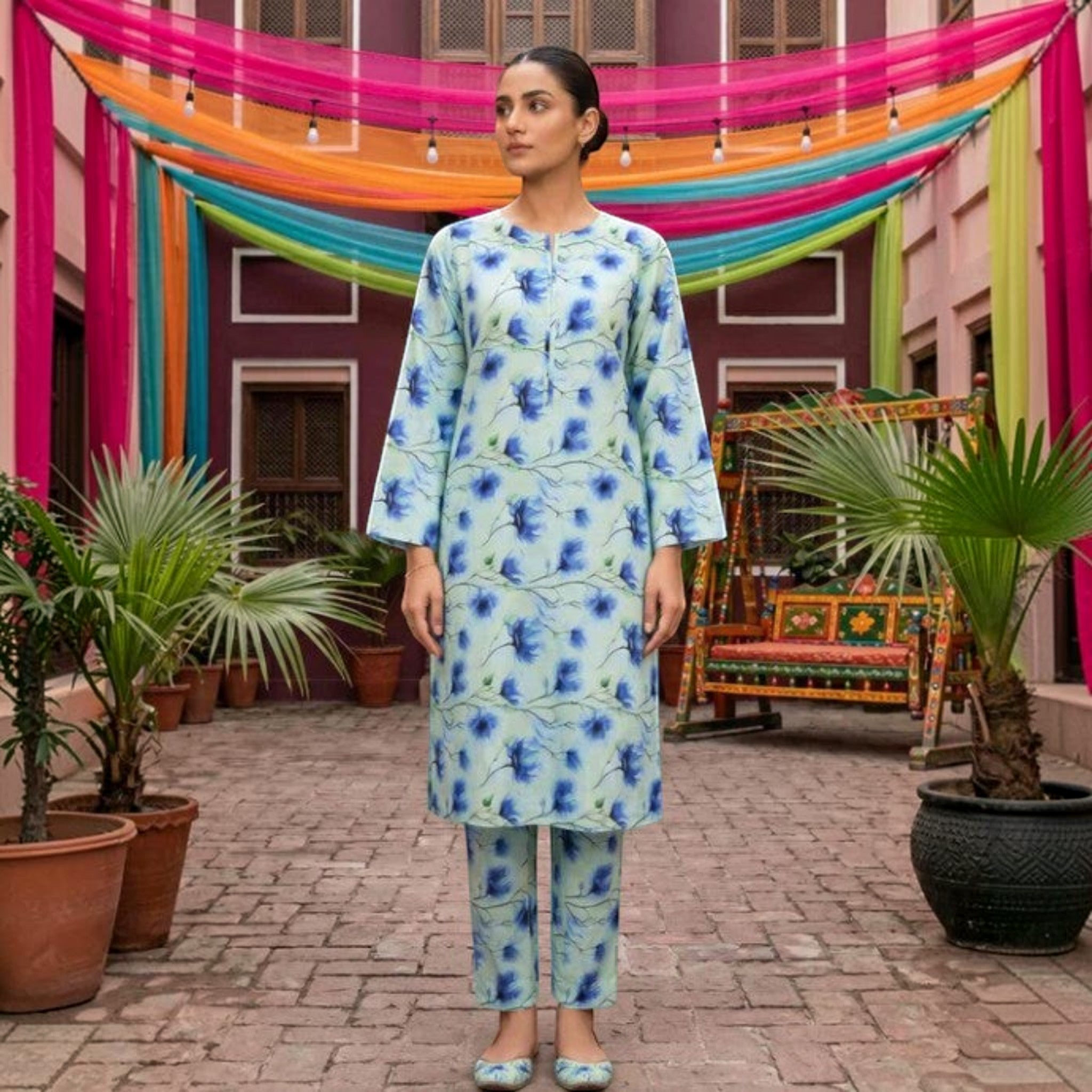 Model wearing a Saha Couture Tawakkal 2-piece mint green lawn suit with blue floral print and matching trousers.